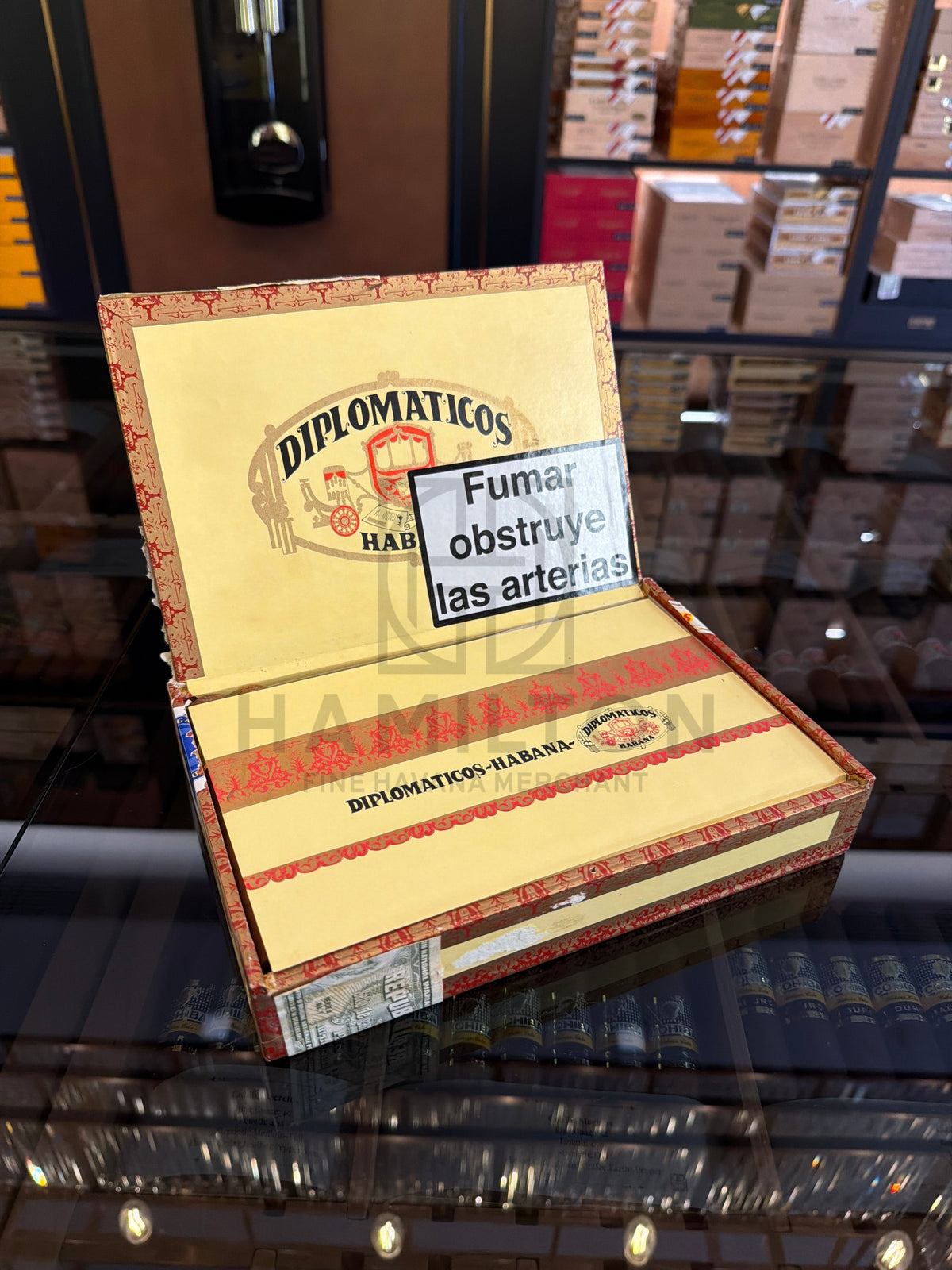 HAMILTON vintage 2002 Diplomaticos No.4 cigar box with ornate red and gold branding on a glass display shelf