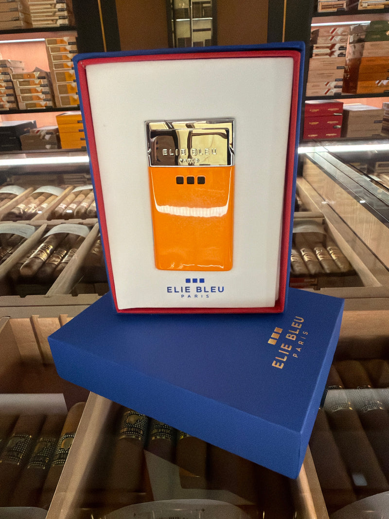 Elie Bleu Paris lighter in its original blue and red presentation box, displayed on top of a blue Elie Bleu box inside what appears to be a cigar shop.