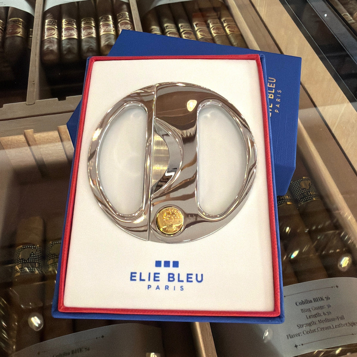 HAMILTON ELIE BLEU round cigar cutter with polished silver handles and a gold button in a blue presentation box