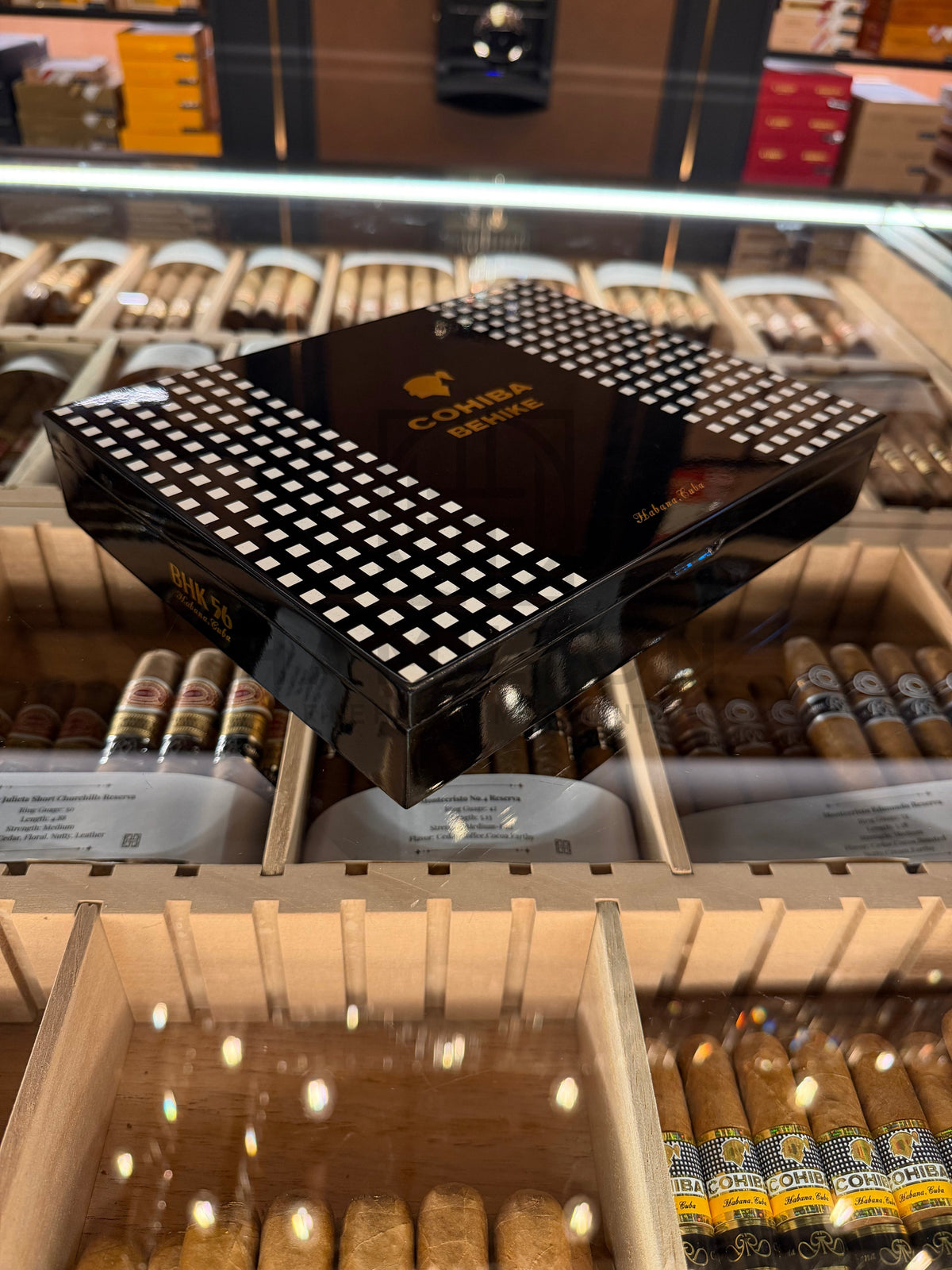 HAMILTON COHIBA Behike BHK 56 cigar box in glossy black with signature white grid pattern on display in a humidor